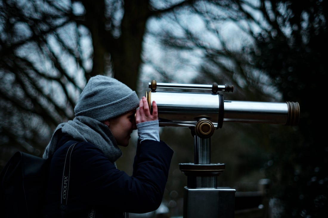 image of a girl looking through a telescope for an article on focus by Larry G. Maguire