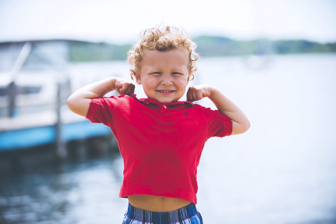 image of a strong small kid in a red t shirt for article by Larry G. Maguire