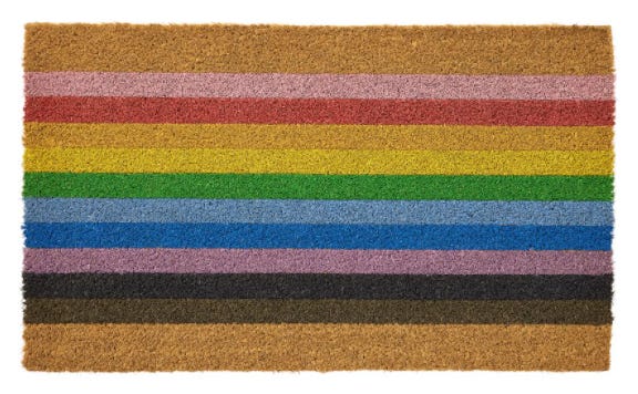 Image of course, rectangular doormat with horizontal rainbow stripes including a black stripe and a brown stripe. It looks like an LGBTQIA pride flag.