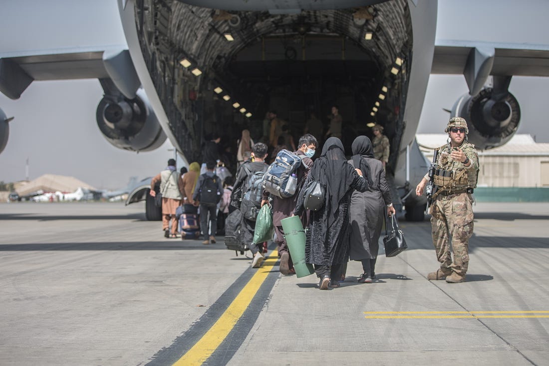 Families begin to board a U.S. Air Force C-17 Globemaster III transport plane during an evacuation at Hamid Karzai International Airport, Afghanistan, August 23, 2021. U.S. Marine Corps/Sgt. Samuel Ruiz/Handout via REUTERS.