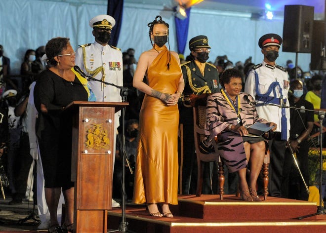 Barbados's Prime Minister Mia Mottley (L) asks the country's new President Sandra Mason (seated R) to make Barbadian singer Rihanna (C) the country's 11th National Hero during a ceremony to declare Barbados a republic.