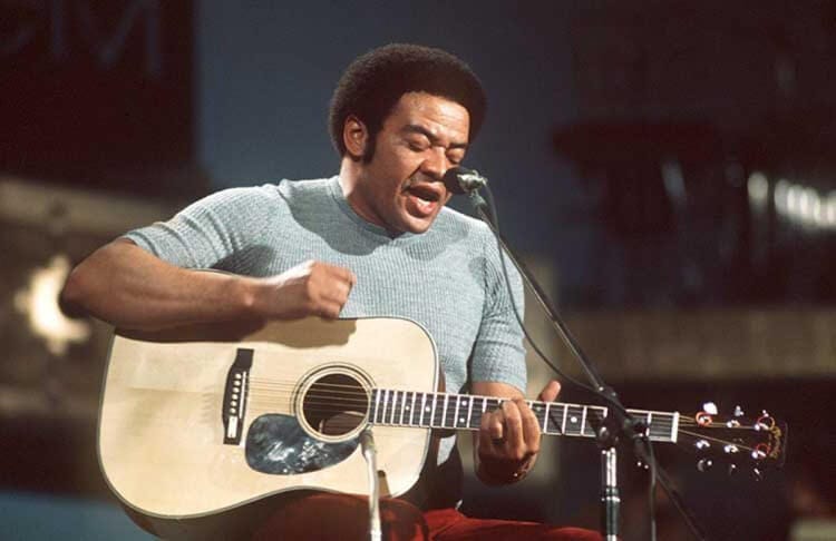 Bill Withers performing with acoustic guitar