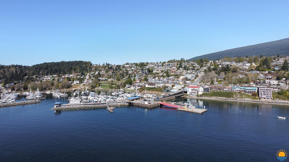 Drone photo of Gibsons Harbour as seen from the water. The surrounding town of Gibsons is in the background.