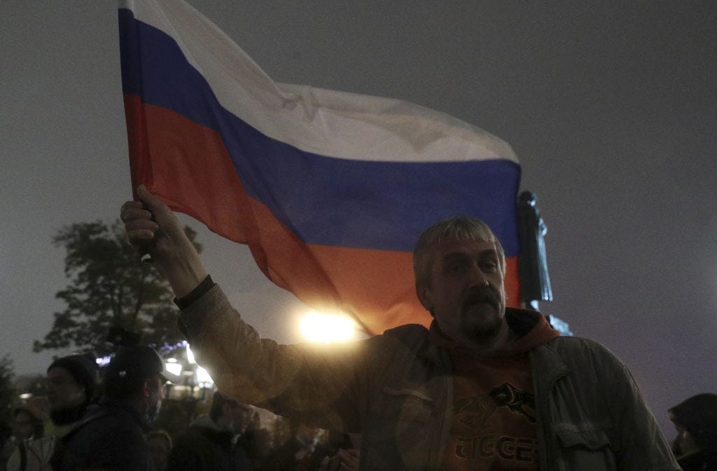 A demonstrator holds a Russian national flag during an unsanctioned protest in central Moscow against the results of the 2021 Russian parliamentary election. / (Alexander Shcherbak / Getty Images)