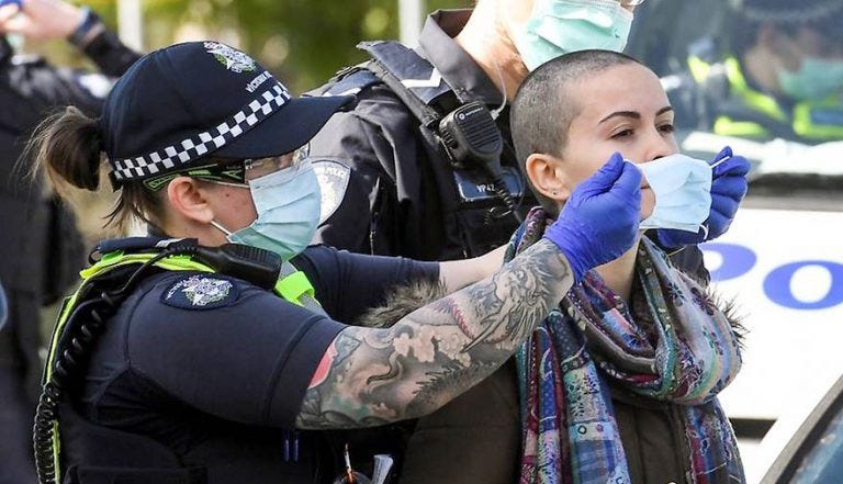 An Australian lockdown protestor gets Covid-masked by a police officer.