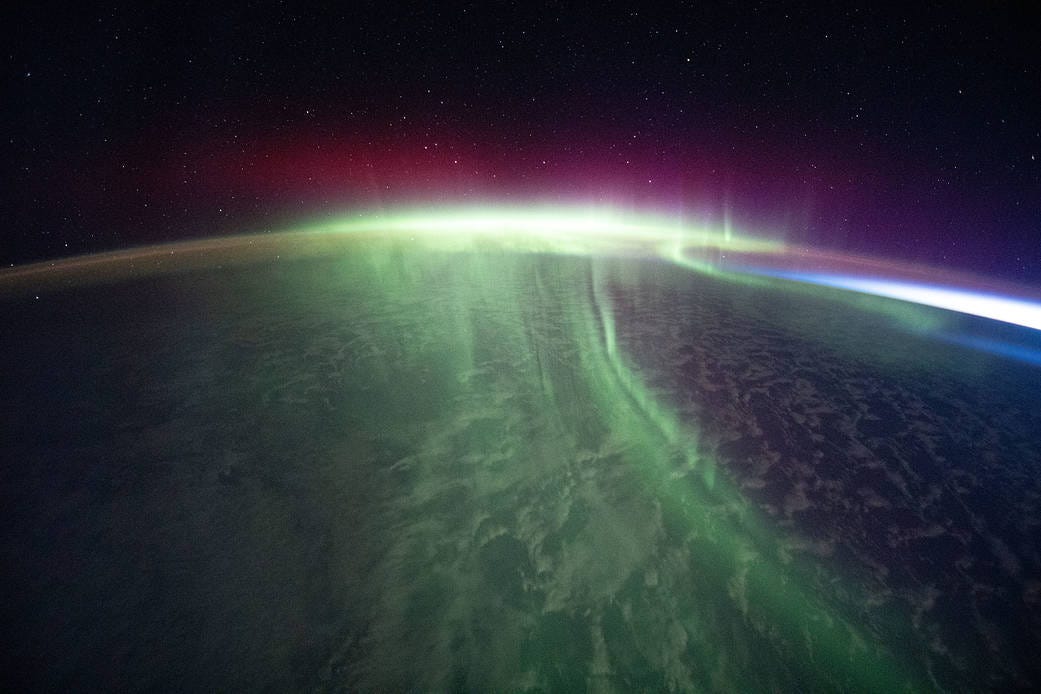 A vivid aurora streams over the Earth