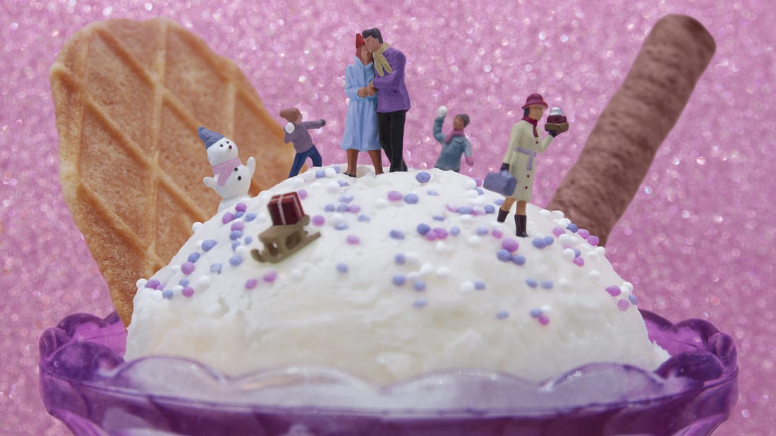 Plastic figures stand atop a giant icecream cornet.