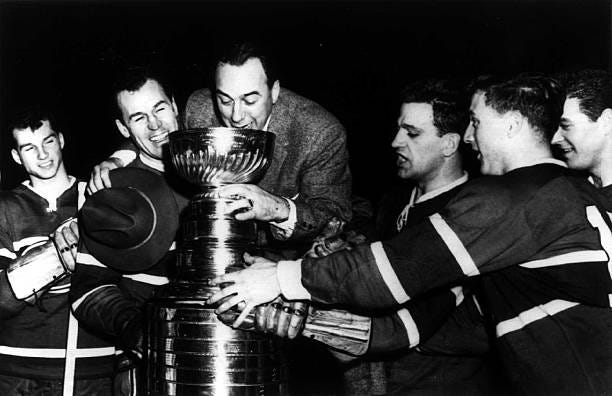 First year Montreal Canadiens coach Toe Blake drinks from the Stanley Cup with Don Marshall, Captain Butch Bouchard, Bernie Geoffrion, Dickie Moore,...