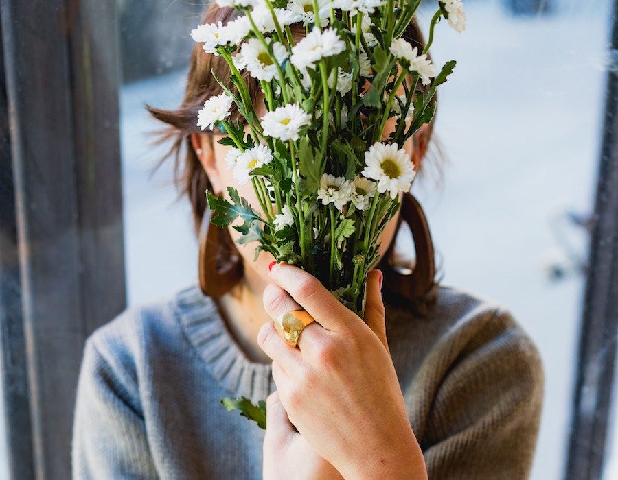 Lady hiding her face behind flowers