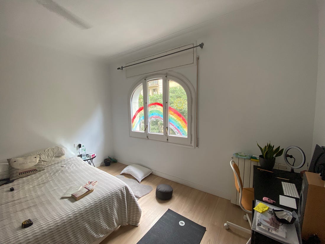 A bedroom with a rainbow painted on the window