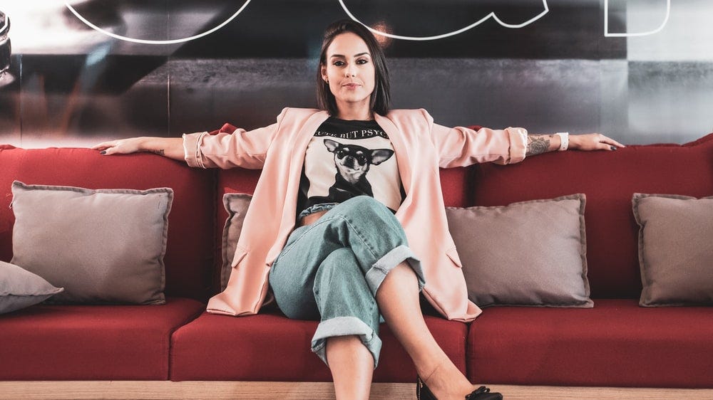 woman in black and white crew neck t-shirt sitting on red couch woman in black and white crew neck t-shirt sitting on red couch