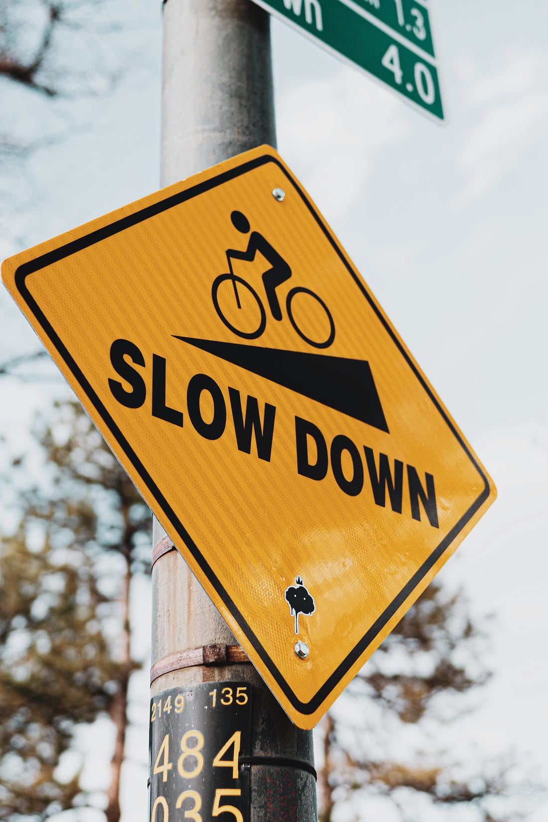 Traffic sign saying "slow down" with image of cyclist