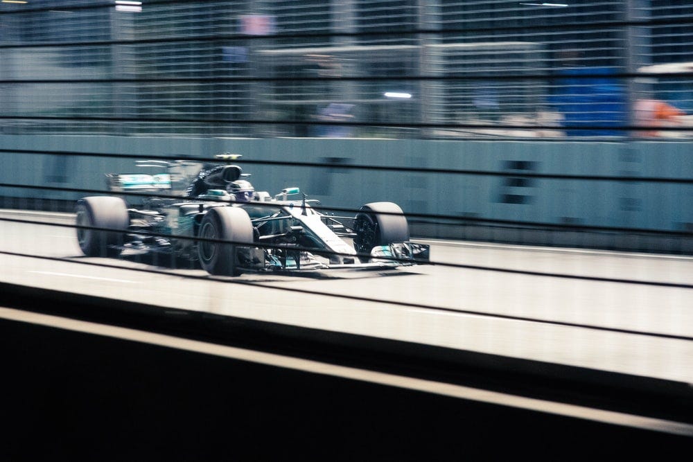green Formula 1 car on grey track at daytime