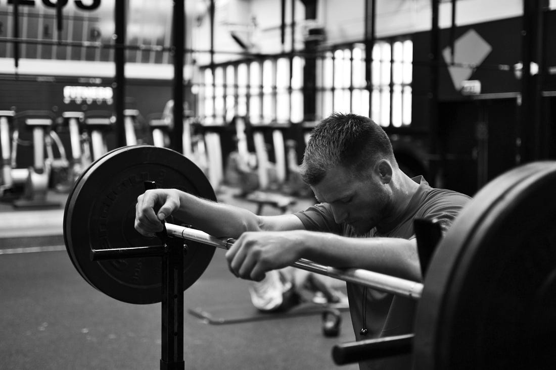 black and white image of a guy leaning on a weights rack for article by Larry G. Maguire