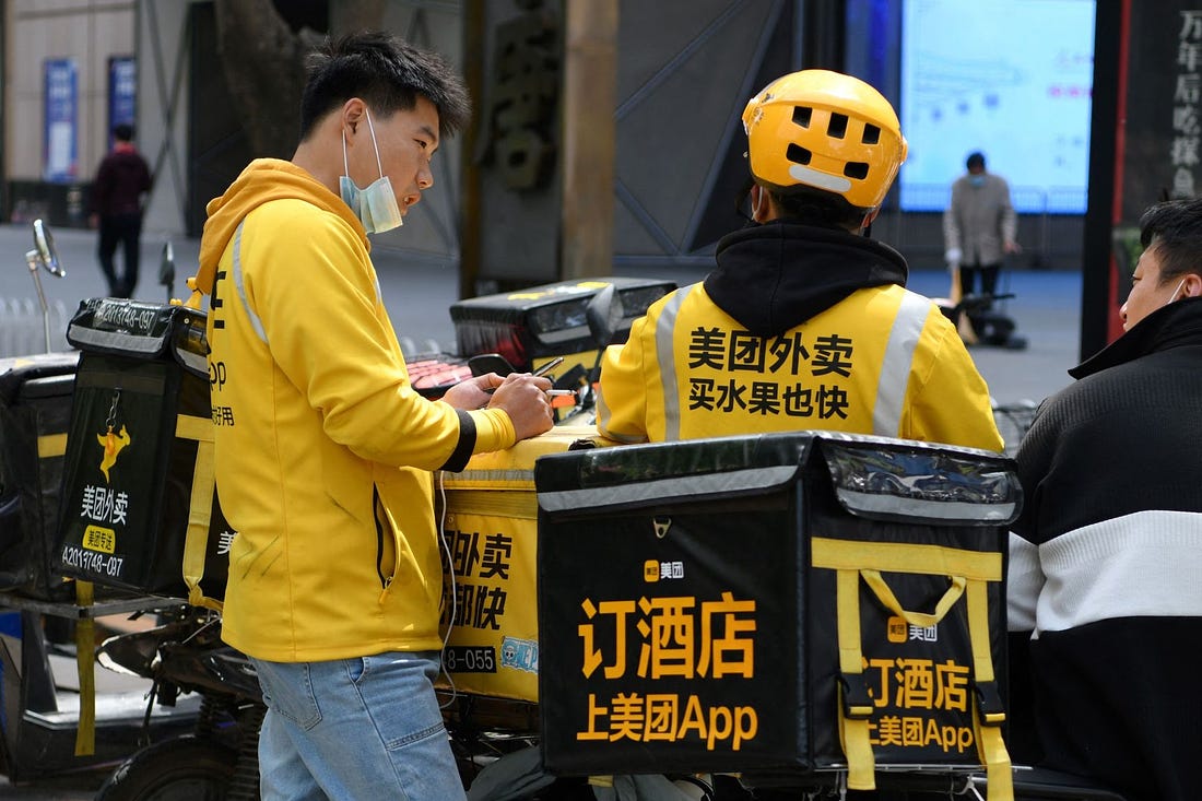 Delivery riders for Meituan, China's biggest provider of food-delivery and related services, wait for orders outside a Beijing restaurant. PHOTO: GREG BAKER/AGENCE FRANCE-PRESSE/GETTY IMAGES