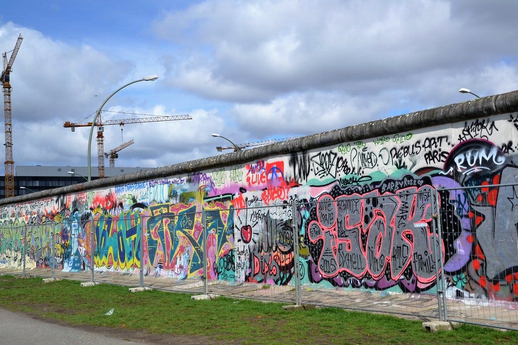 "Berlin, wall & cranes" by Jeanne Menjoulet is licensed under CC BY-ND 2.0