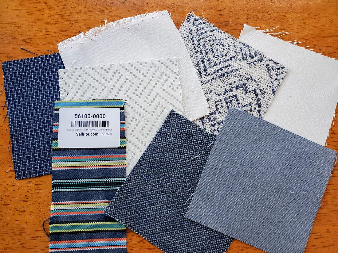 Image: square samples of Sunbrella fabric in blues and whites on a wood table top.