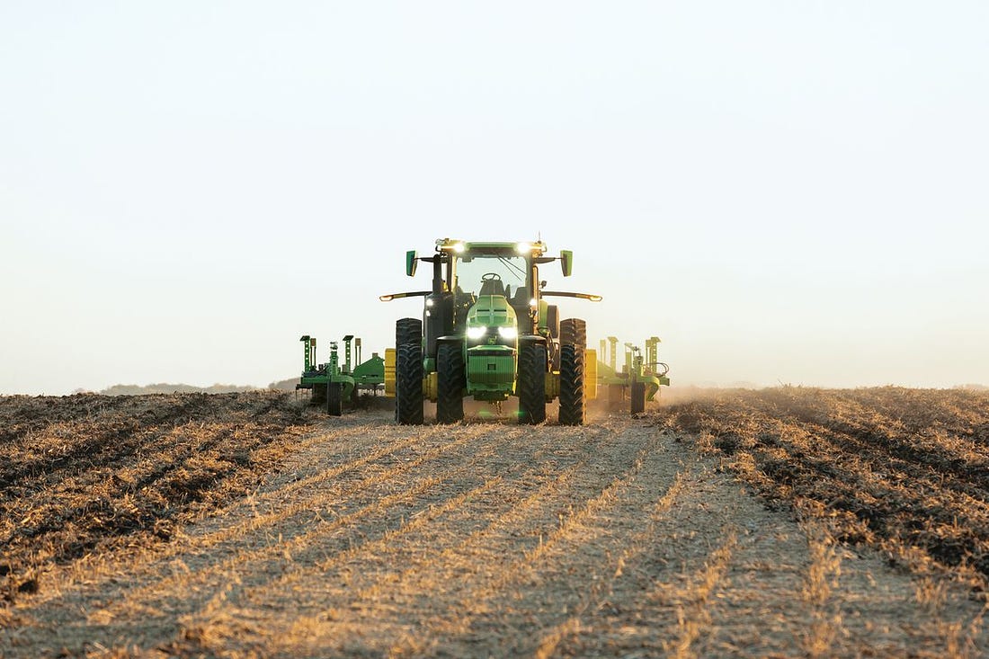 A tractor plowing a dirt field.