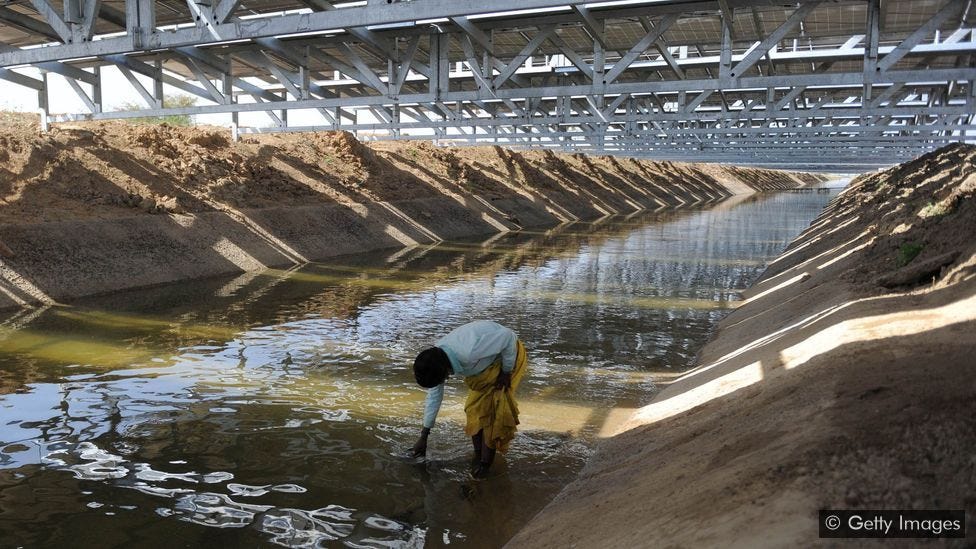 The solar canals are suspended on a metal structure over the canal, with benefits for both water conservation below and cooling of the panels above (Credit: Getty Images)