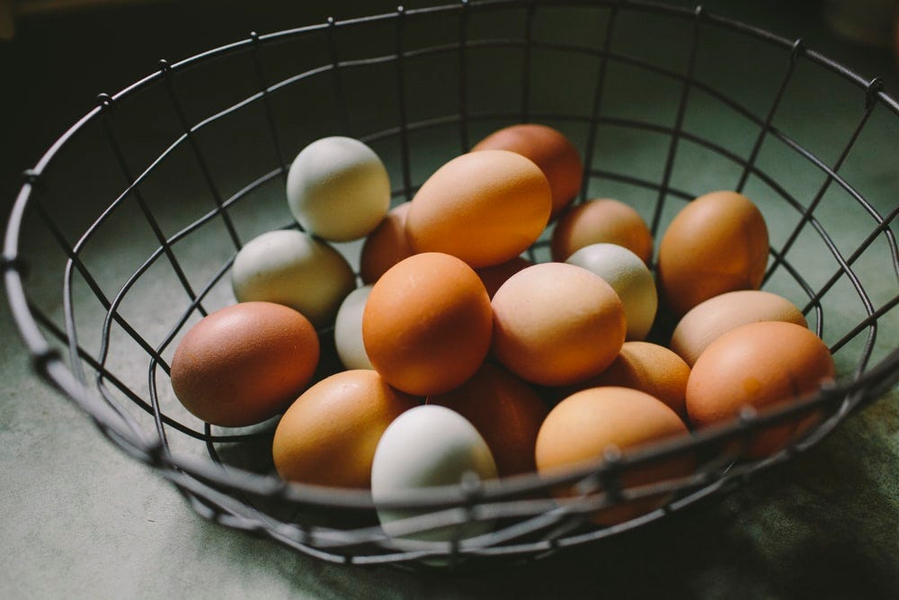 brown and white eggs on gray basket