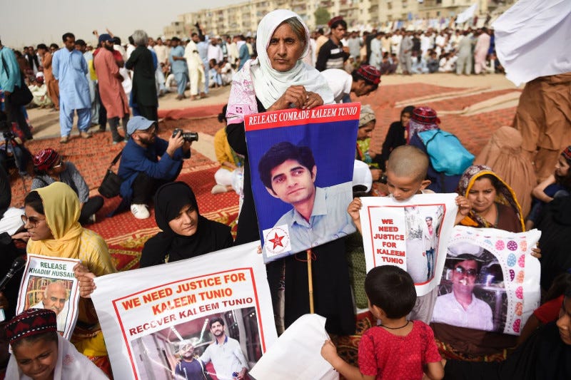 Family members of missing Pakistanis hold photos of their relatives at a Pashtun Tahafuz Movement protest rally in Karachi, Pakistan, on May 13, 2018.