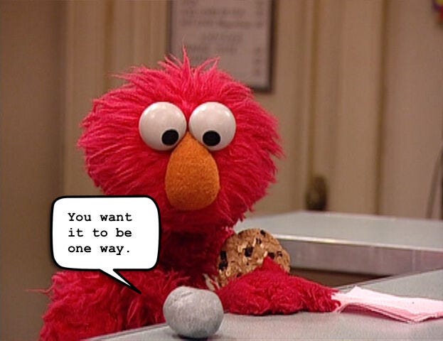 Elmo the Sesame Street Muppet holds an oatmeal raisin cookie (his favorite) and looks in apparent dismay at Rocco (a regular-ass rock) on the table in front of him. In a word balloon, Rocco quotes the Wire’s Marlo Stanfield saying “You want it to be one way.”