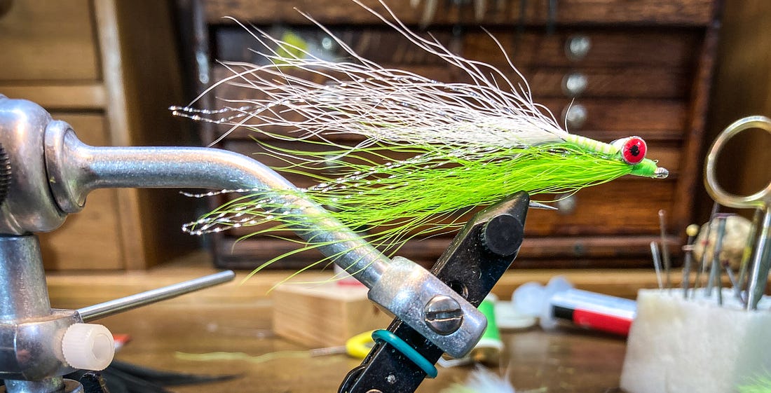 A chartreuse and white Clouser minnow in a rotary vice. [Photo: Dean Shadley]