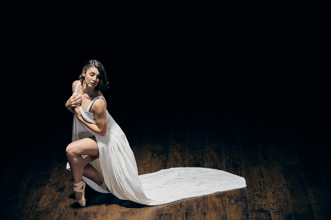 Ballerina posing on pointe wearing white dress