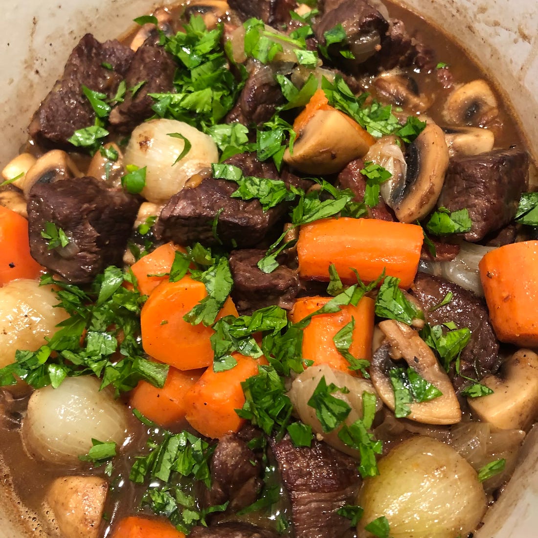 Boeuf Bourguignon with carrots in a stew pot.