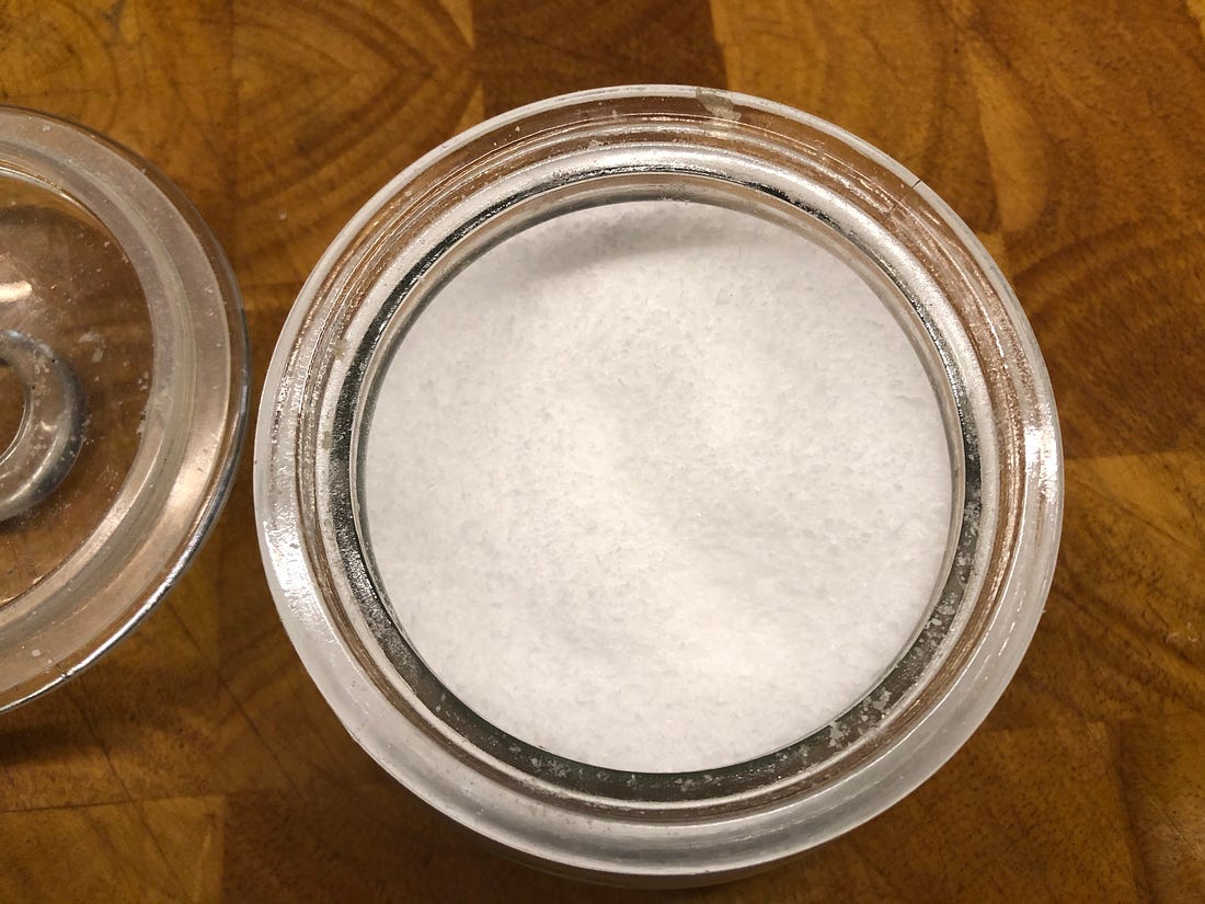 Overhead shot of a glass container of coarse Kosher salt