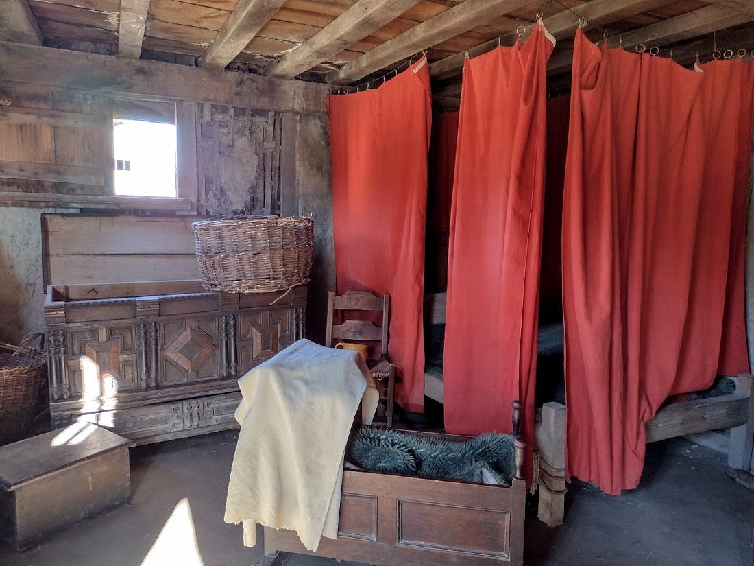 Room with curtained bed, cradle
