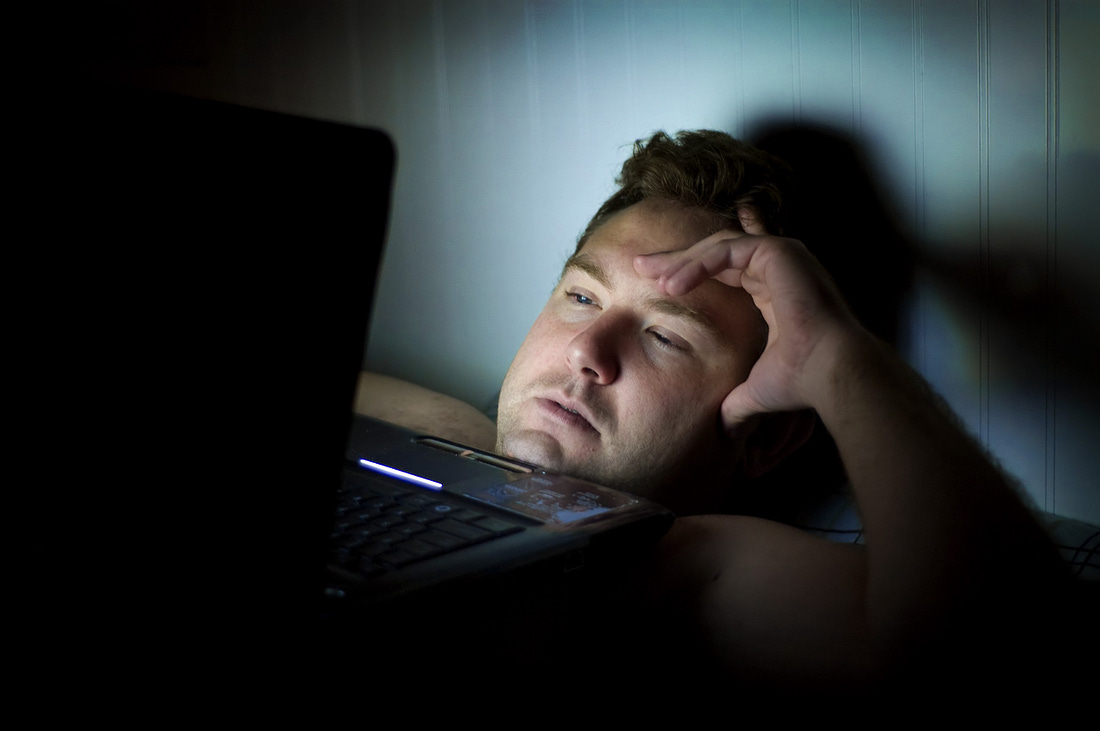 Man on his laptop in a dark room for article by Larry G. Maguire