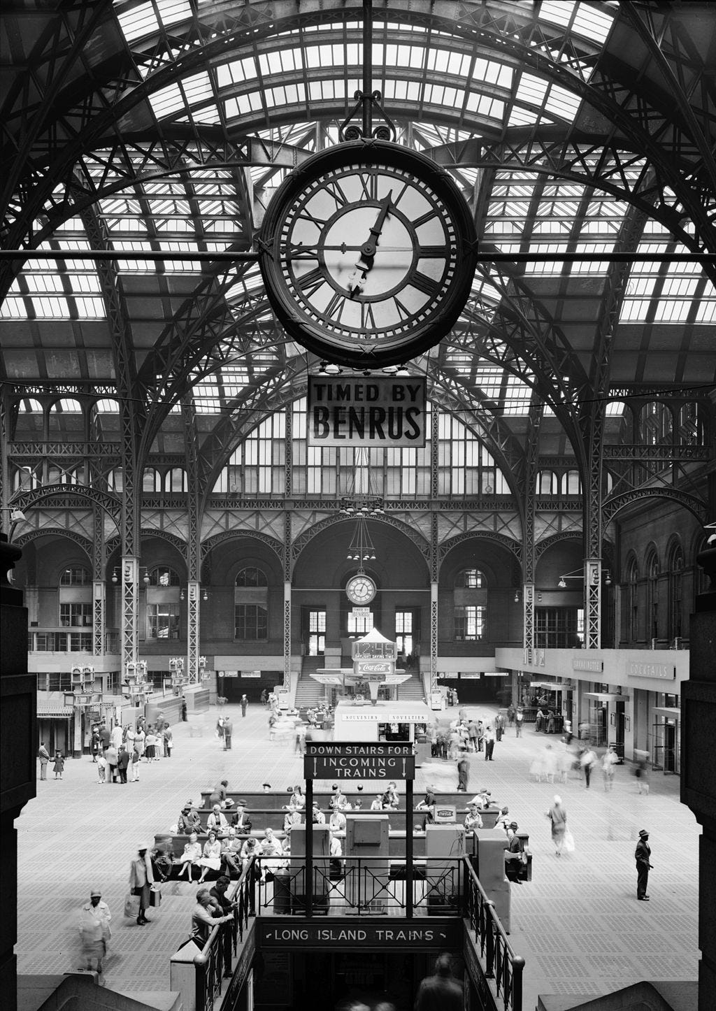 A large clock under a glass dome over the exit concourse
