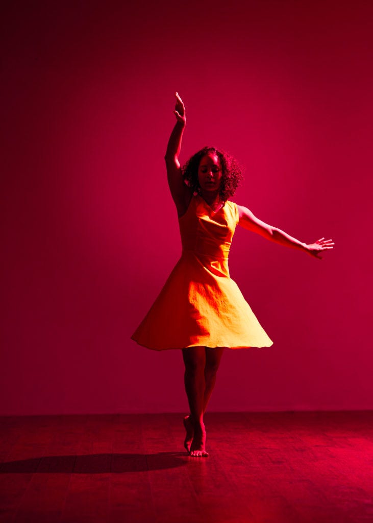 Dancer in yellow dress on red background