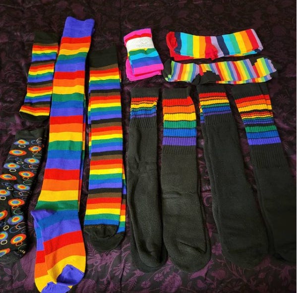 Photo of eleven pairs of various rainbow striped knee socks and thigh-high socks