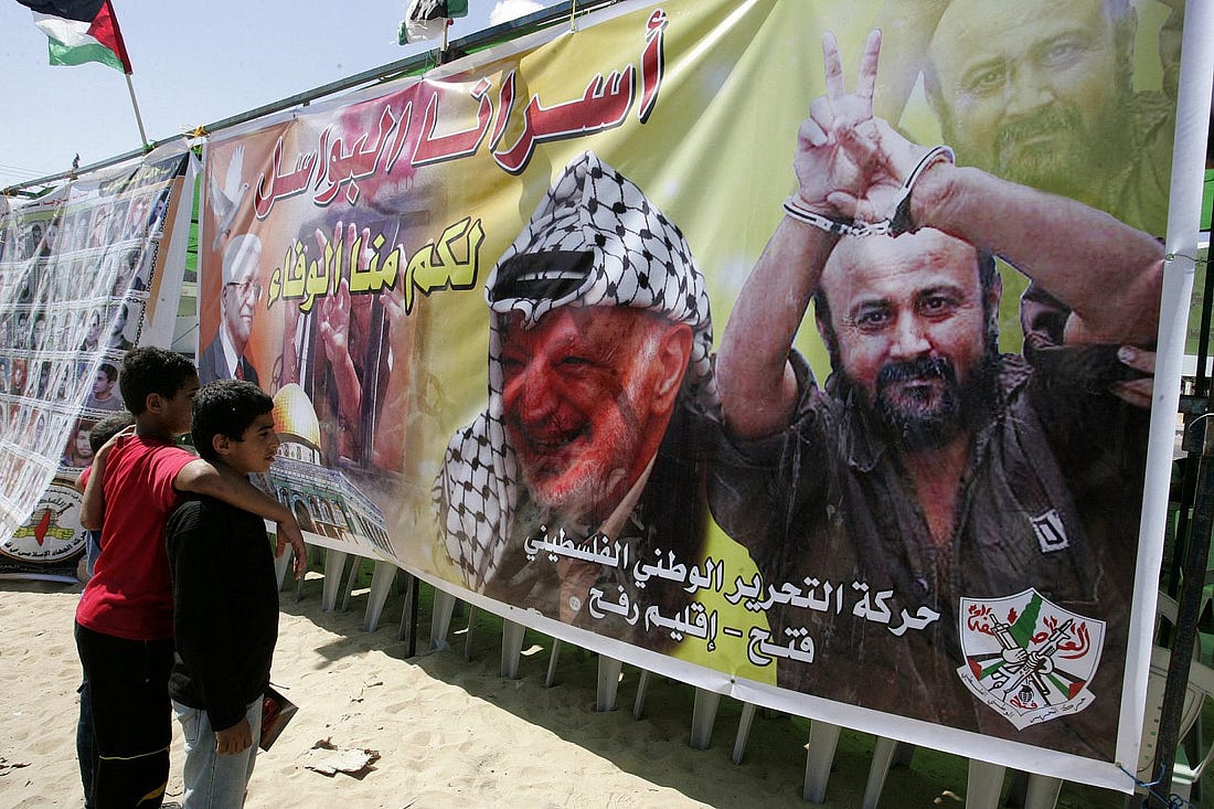 Palestinian children stand next to the image of Fatah leaders Yasser Arafat and Marwan Barghouti during a demonstration in support of prisoners on hunger strike in Israeli jails, in Rafah, Gaza Strip, Oct. 6, 2011. (Abed Rahim Khatib/Flash90)