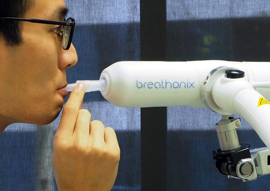 A staff member demonstrates the usage of Breathonix breathalyzer test kit developed by Breathonix, a start-up by the National University of Singapore, able to detect the coronavirus disease (COVID-19) within a minute according to the company, at their laboratory in Singapore October 29, 2020. REUTERS/Chen Lin/File Photo
