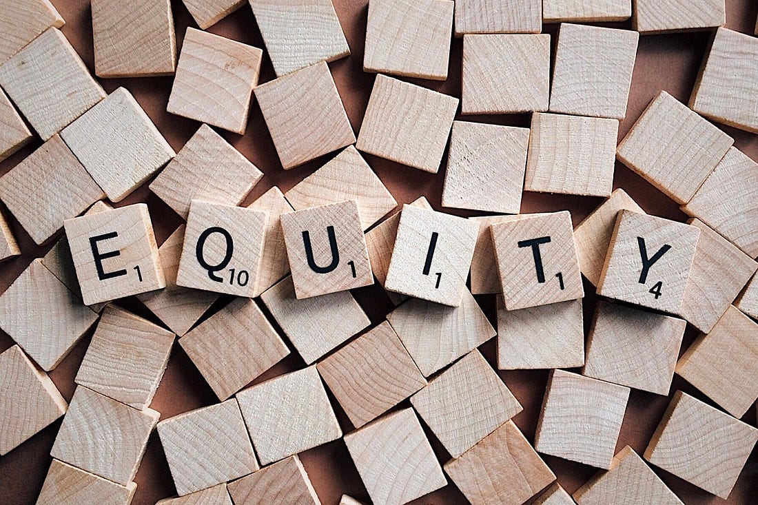 Equity spelled with scrabble tiles