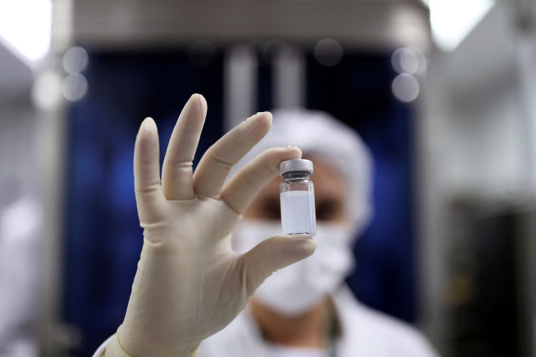 An employee holds a vial containing Sinovac Biotech's vaccine against COVID-19 at the Butantan biomedical production centre in Sao Paulo [Amanda Perobelli/Reuters]