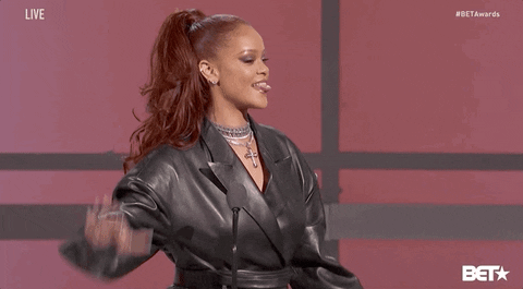 Rihanna holds up her hand to her ear, gesturing to an unseen audience, "I want to hear you." [gif]