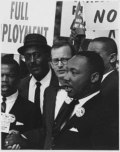 Martin Luther King, Jr., speaking surrounded by other men. Martin Luther King, Jr., speaking surrounded by other men.