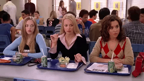 The mean girls roll their eyes whilst sitting at a lunchtable [gif]