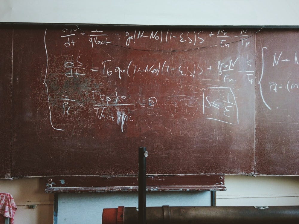 written equations on brown wooden board written equations on brown wooden board