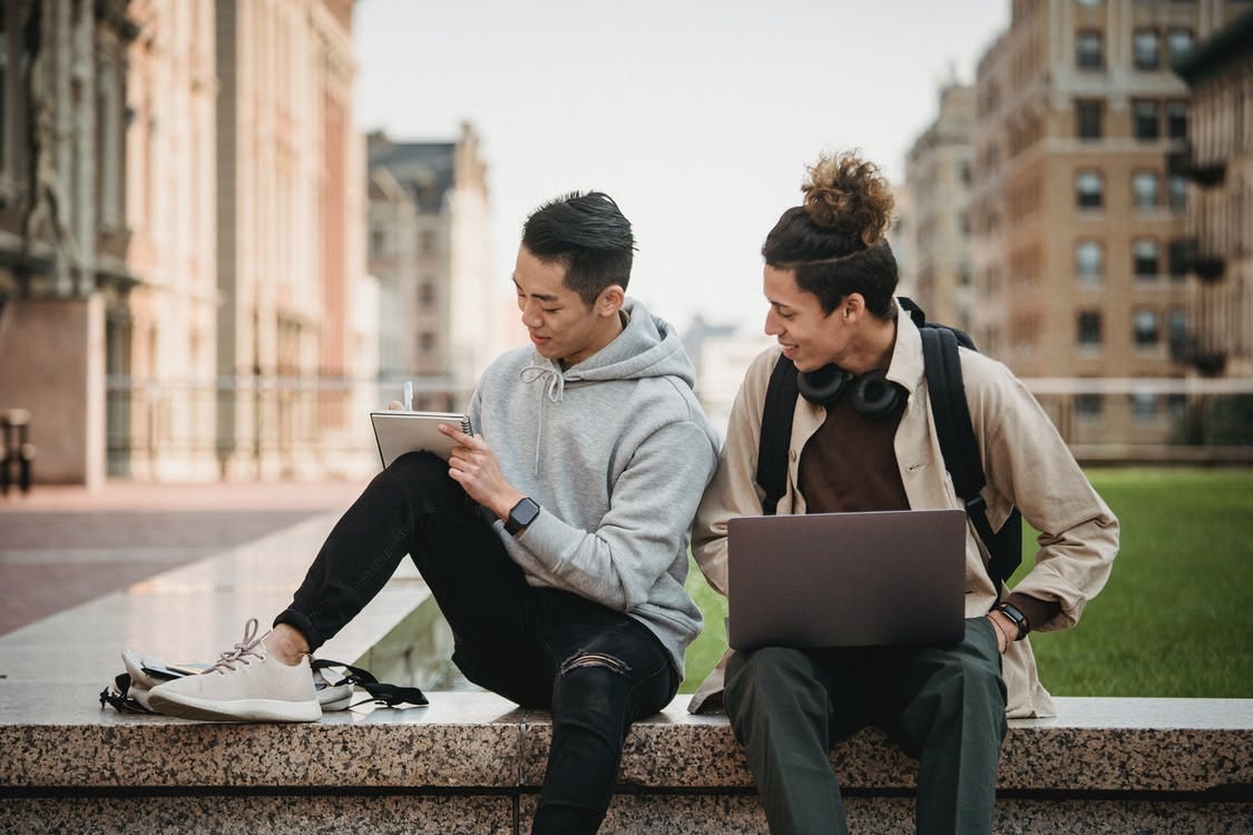 Man and Woman Sitting on Concrete Bench Using Laptop Computers Man and Woman Sitting on Concrete Bench Using Laptop Computers