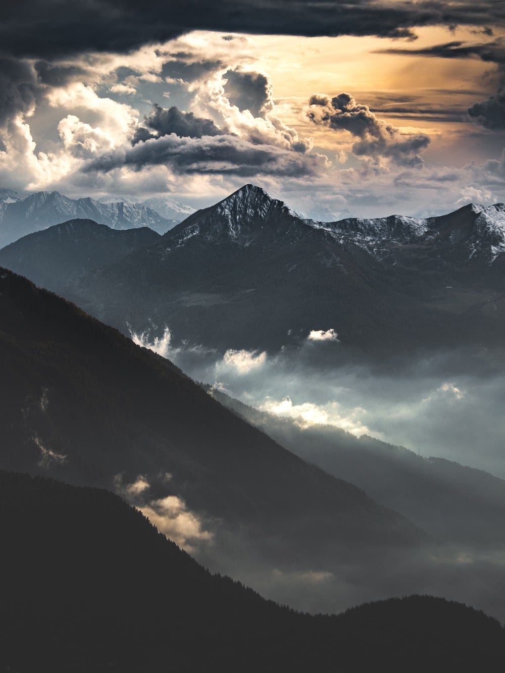 black and white mountains under cloudy sky during daytime black and white mountains under cloudy sky during daytime