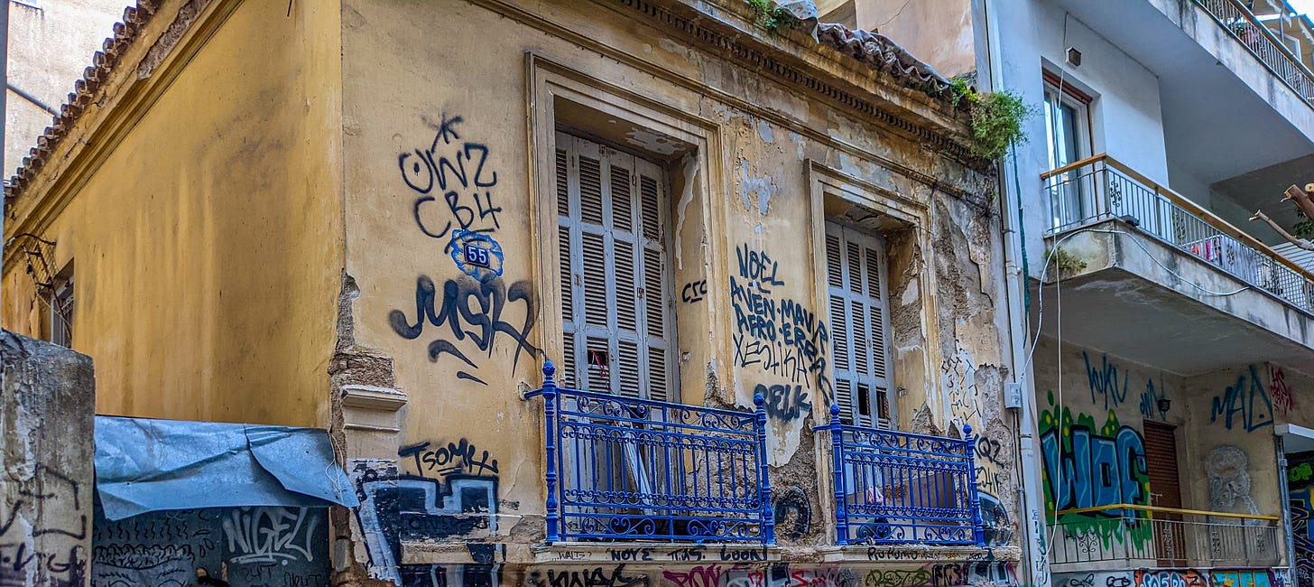A dilapidated building showing various incomprehensible graffiti. 