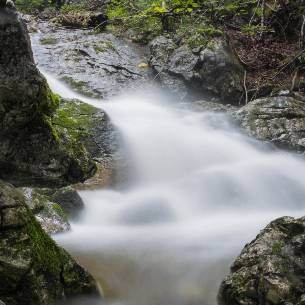 water falling down moss-covered rocks. water falling down moss-covered rocks.