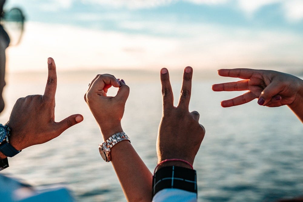 two persons forming love fingers two persons forming love fingers
