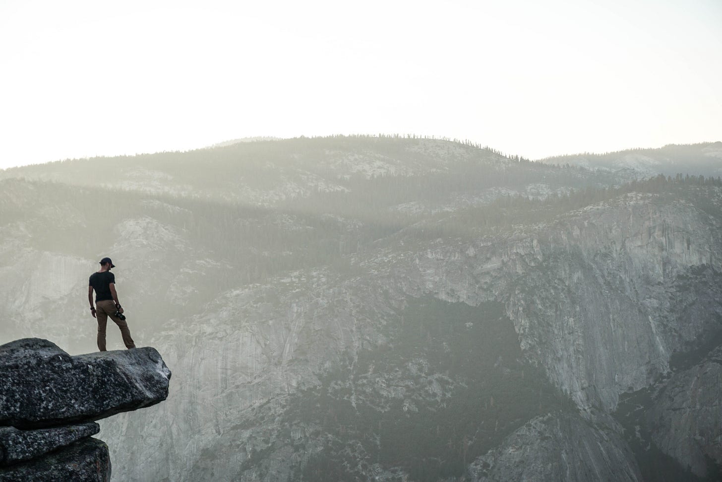 Person standing on ledge in mountains