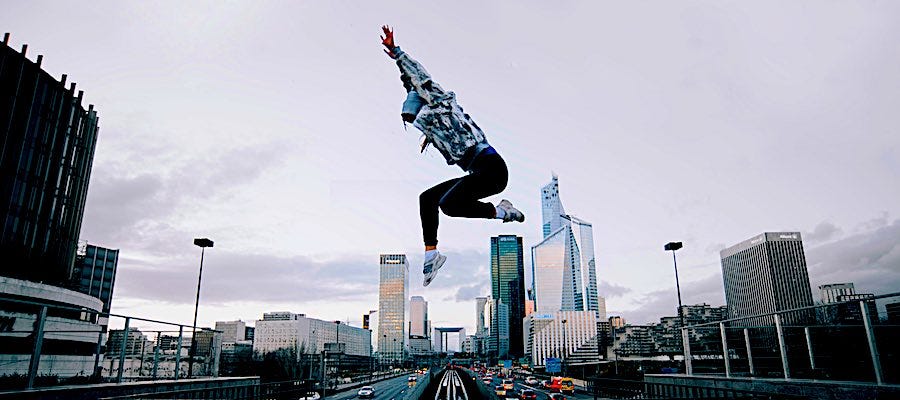 Person leaping through the air city in background Person leaping through the air city in background